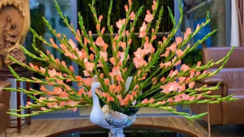 Một bình cắm hoa tuyết mai theo dáng tự nhiên, các cành vươn ra thanh thoát và cân đối trong một chiếc bình cao